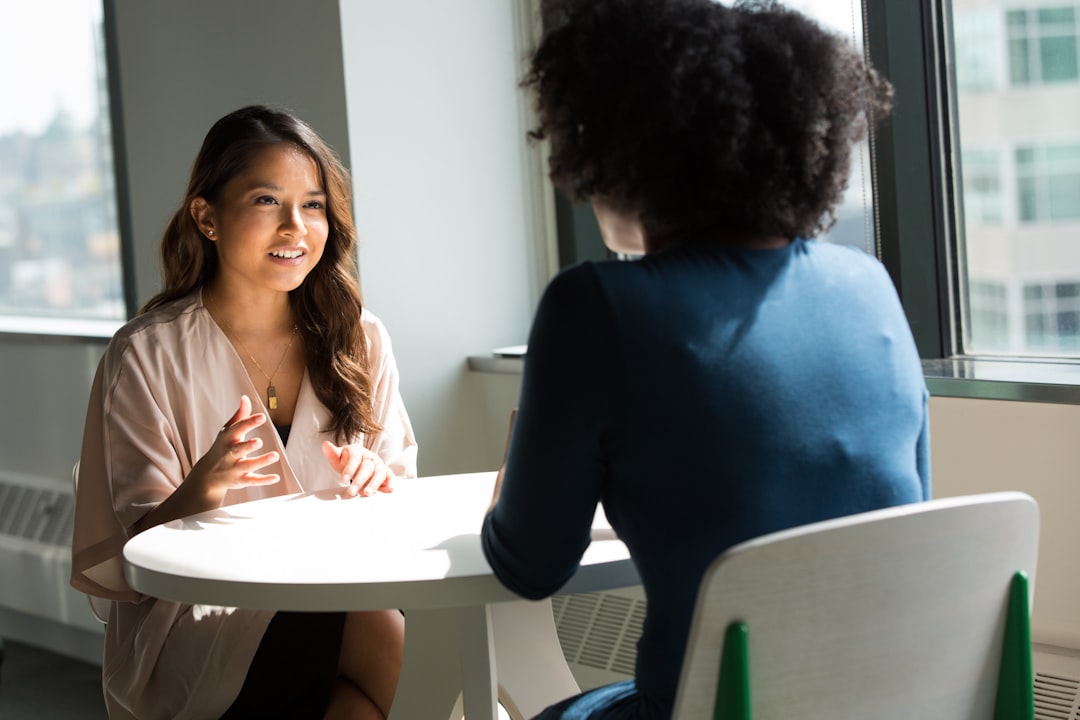 Two colleagues in a one-on-one coaching conversation at the office