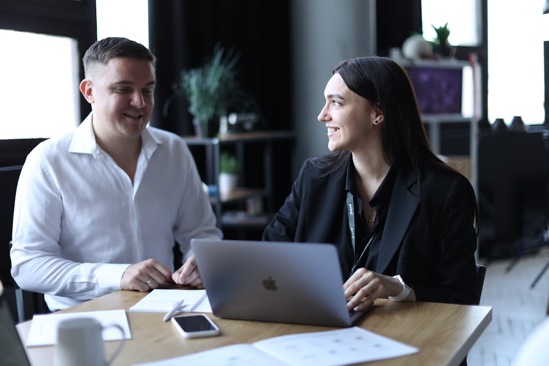 Two professionals reviewing numbers together in an office, building a sales coaching business case